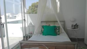 un letto a baldacchino con un cuscino verde di Apartamento Calero a Puerto Calero