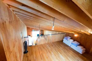an attic room with a wooden ceiling with pillows at Sakura Garden in Otaru