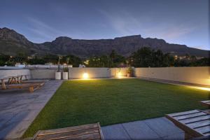 Cape Town的住宿－三號精品酒店，后院设有草坪,后院背景为群山