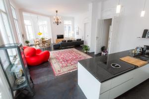 kuchnia i salon z czerwonym krzesłem w obiekcie Grand Soho Apartment w Wiedniu