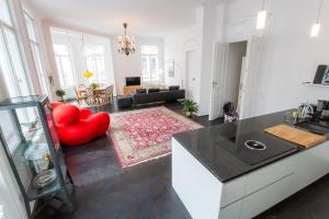 ウィーンにあるGrand Soho Apartmentのキッチン、リビングルーム(赤い椅子付)