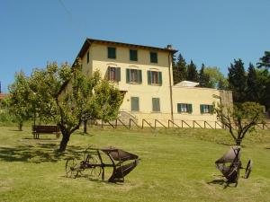 uma grande casa branca com um tractor num campo em Agriturismo Fattoria Sant'Appiano em Barberino di Val dʼElsa