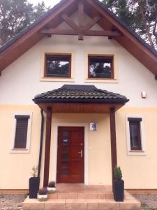 a house with a red door and windows at Villa Złote Wydmy in Międzywodzie