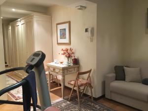 un soggiorno con tapis roulant, tavolo e divano di Villa Castiglioni Apartment a Laglio