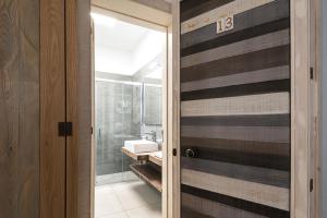 a bathroom with a door leading to a sink at B&B Il Palazzotto di Luca Luxury Suites in Lecce +58 photos