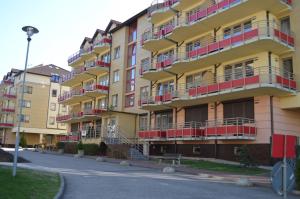 żółty budynek z czerwonymi balkonami na ulicy w obiekcie Apartament Zdrojowa u Heleny w Świnoujściu +7 zdjęć