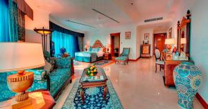 a living room with a couch and a bed at Grand Excelsior Hotel - Bur Dubai in Dubai