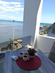 zwei Kaffeetassen auf einem Tisch mit Meerblick in der Unterkunft Sea Star Apartments in Ulcinj