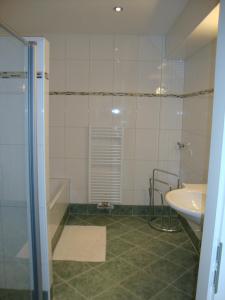 a bathroom with a shower and a sink and a tub at My Adventure Appartements Schladming by Schladmingurlaub in Schladming