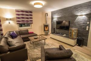 ein Wohnzimmer mit einem Sofa und einem Flachbild-TV in der Unterkunft Villa Fleesenstrand in Göhren-Lebbin