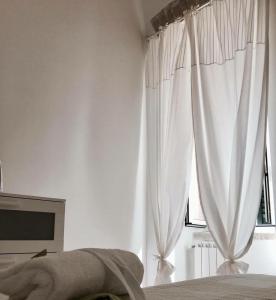 テルリッツィにあるIl Fiore all'Occhielloのベッドルーム(白いカーテン、窓付)