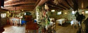 a restaurant with tables and chairs and a brick wall at Casa Rural Araceli in Yésero
