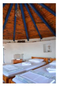 a room with four beds and a wooden ceiling at Milos Vaos Windmill in Plaka Milou
