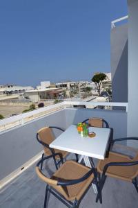 een witte tafel en stoelen op een balkon met uitzicht bij Ialysos City Hotel in Ialyssos