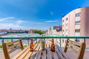 a wooden table with beer bottles on a balcony at Avenida & Mercado by Home Sweet Home Aveiro in Aveiro