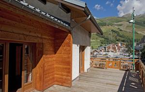 a wooden building with a staircase on a deck at Odalys Chalet Le Marmotton in Les Deux Alpes