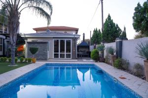 a swimming pool in the backyard of a house at Cycad Palm Hotel in Gaborone