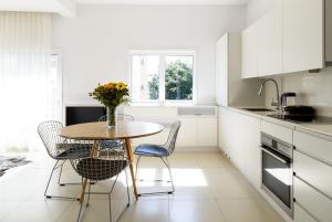 a kitchen with a table with chairs and a vase of flowers at Relax & Sunny near Beach by FeelHome in Tel Aviv +4 photos