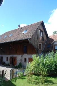 Cette grande maison en bois est dotée de fenêtres et d'une clôture. dans l'établissement Gites Les Petits Tisserands, à Epfig