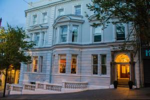 倫敦德里的住宿－施奎精品酒店，一条街道上带门廊的大型白色建筑