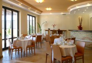 a dining room with tables and chairs and windows at On The Rocks in Palaiochora
