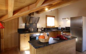 a kitchen with a refrigerator and a counter top at Odalys Chalet Levanna Occidentale in Les Deux Alpes