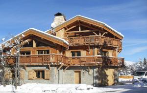 a large wooden house with a balcony in the snow at Odalys Chalet Levanna Occidentale in Les Deux Alpes
