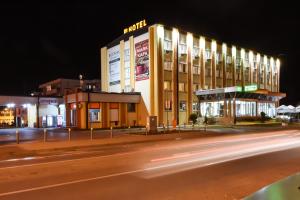 a building on the side of a street at night at Hotel Požega in Požega