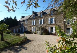 a large stone house with a gravel driveway at Clos St Ange (Dinan-St Malo) in Vildé-Guingalan