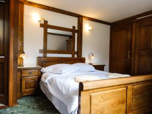 a bedroom with a large bed with a wooden frame at Pensiunea Casa Noastra in Arieşeni