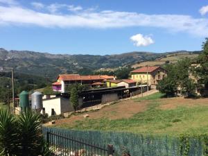 a house on a hill with mountains in the background at Agroturismo Gure Naia in Carranza