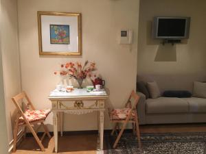Villa Castiglioni Apartment في لاليو: غرفة معيشة مع طاولة وكراسي وأريكة