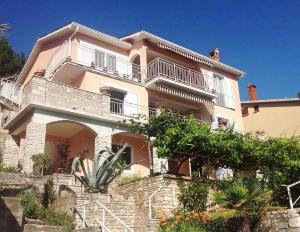 a large house with a balcony on top of it at Apartments Alma in Rabac