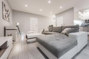 a white living room with a couch and a table at Apartament Silesian Vip in Zabrze