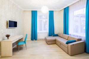 a living room with blue curtains and a couch at Crystal Apartments in Lviv