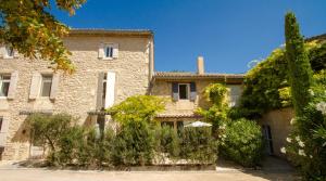 un grand bâtiment en pierre avec des arbres devant lui dans l'établissement Hotel du Soleil et Spa, à Saint-Rémy-de-Provence