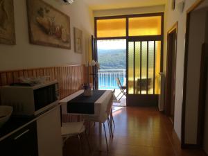 a kitchen with a table and a microwave and a balcony at Apartments Alma in Rabac