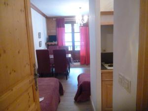 a room with two beds and a kitchen with a table at studio 103.Coeur de val in Val-d'Isère