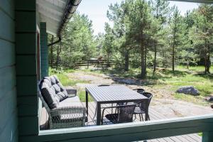 a patio with a table and chairs on a porch at Herrö stugor in Lemland