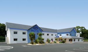 ein Hotel mit einem blau-weißen Gebäude in der Unterkunft Kyriad Quimper - Pont-l'Abbé in Pont-lʼAbbé