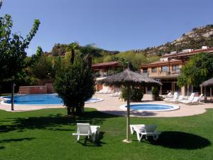 
a beach area with a pool, chairs, and tables at Serra de Prades Resort in Vilanova de Prades
