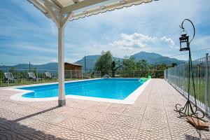 a swimming pool with chairs and a fence at Agriturismo Il Musaccio in Barga