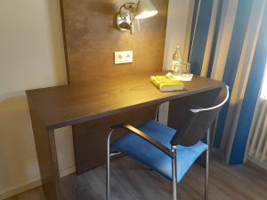 a wooden desk with a blue chair in a room at Tagungshaus Wernau in Wernau