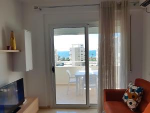 a living room with a sliding glass door leading to a table at Flori beach Apartment Radhime in Radhimë
