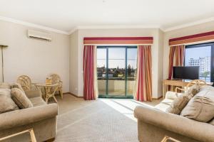a living room with two couches and a television at Riviera Hotel in Carcavelos