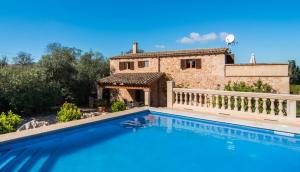 a villa with a swimming pool in front of a house at Es Lladoner Villa in Porreres