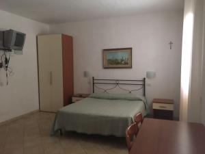 a bedroom with a bed and a table and a tv at Residence Villa Candida in Vieste