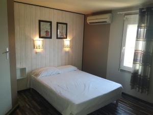 a bedroom with a white bed and two lights on the wall at Fasthotel Montpellier Baillargues in Baillargues