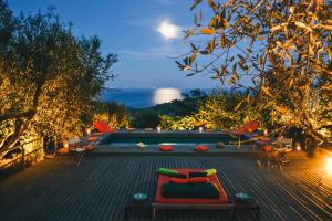 a view of a pool at night with a bench at Borgo degli Ulivi in Porto Ercole