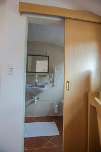a bathroom with a sink and a mirror at Pension Regina in Mayrhofen